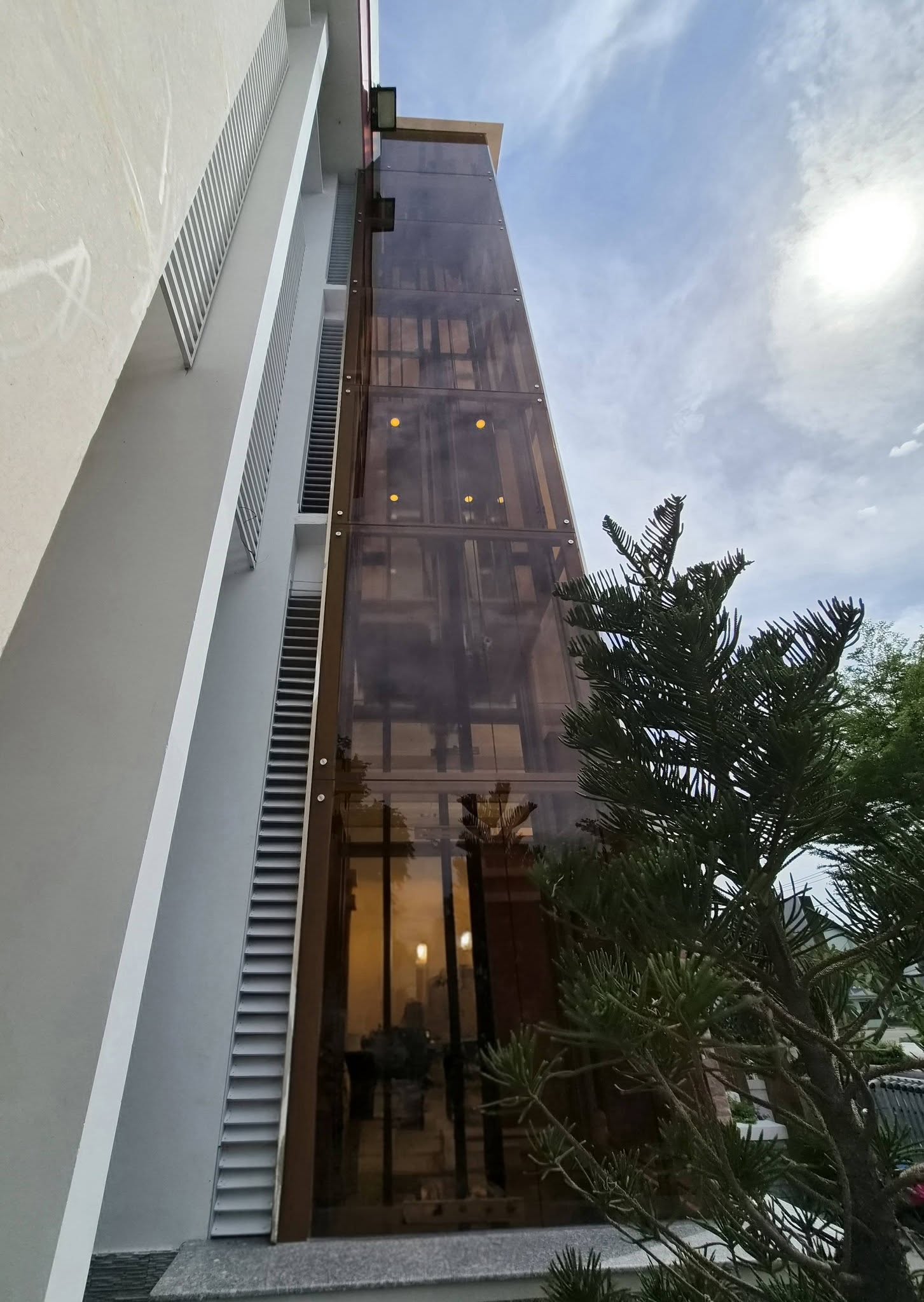 Góc nhìn từ chân thang lên hệ giếng kính và khung thang máy ngoài trời