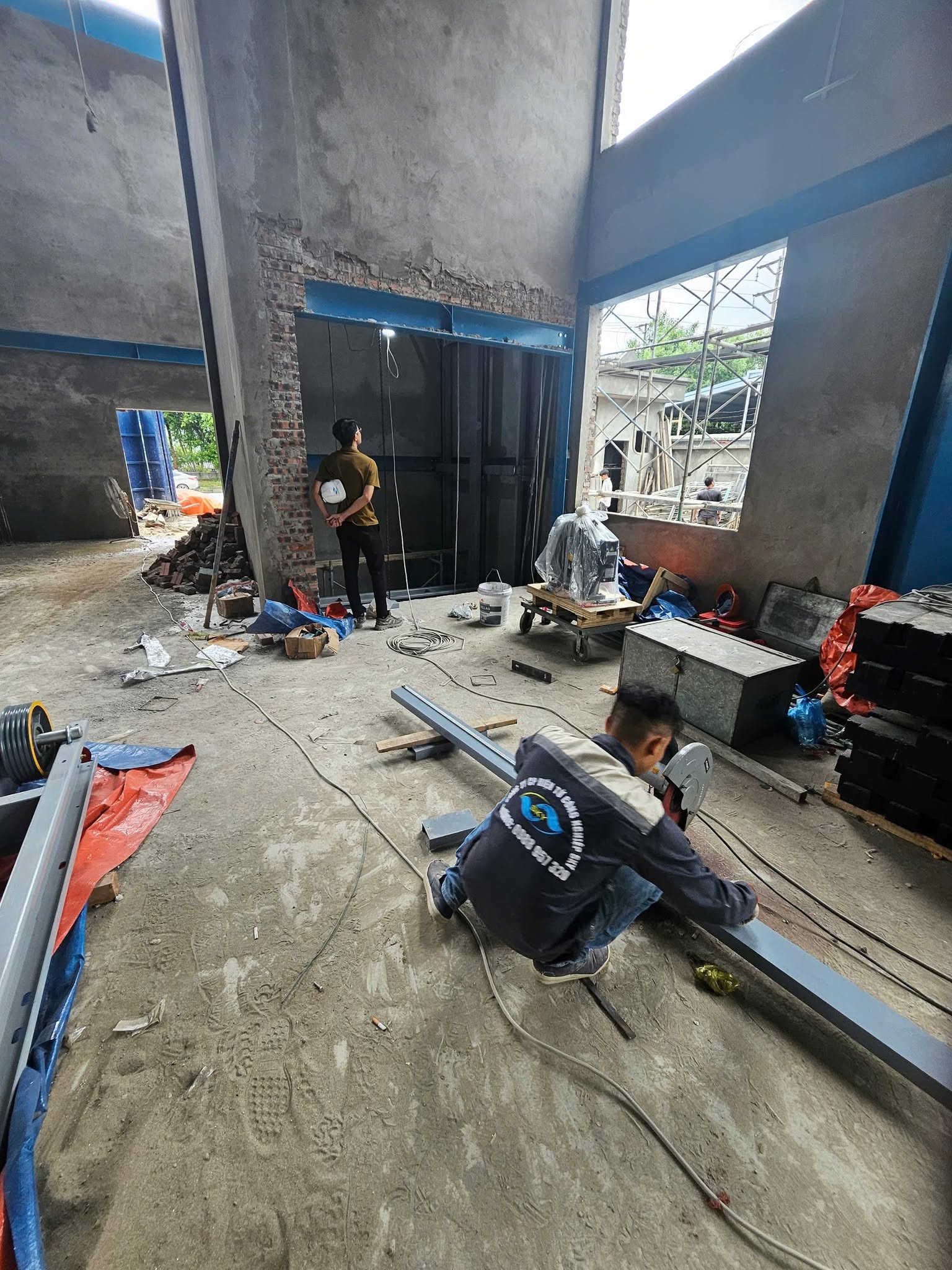 Đội thi công lắp đặt khung thang máy tại công trình Hà Nội
